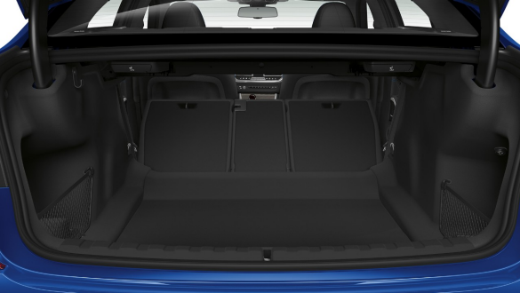 BMW Série 3 Berline, trappe de passage. Gros plan du compartiment à bagages ouvert avec les sièges arrière repliés à demi.