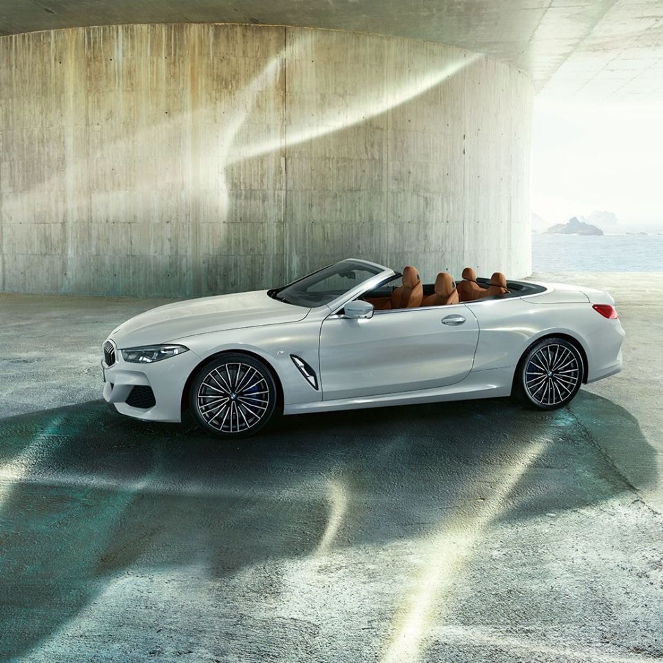 BMW M850i xDrive en Mineralweiß metallic, vue de profil avec capote souple ouverte G14. BMW M850i xDrive en Mineralweiß metallic, vue de profil avec capote souple ouverte G14.