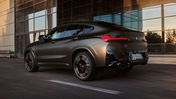 Différentiel M sport BMW X4 M40i M40d G02 LCI 2021 BMW X4 M40i M40d G02 LCI 2021 Facelift différentiel M Sport vue de trois quarts arrière devant une façade en verre