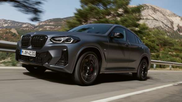 Suspension M sport BMW X4 M40i M40d G02 LCI restylage en 2021, vue avant en mouvement BMW X4 M40i M40d G02 LCI 2021 Frozen Deep Grey suspension M sport, vue de trois quarts avant roulant devant un paysage de collines