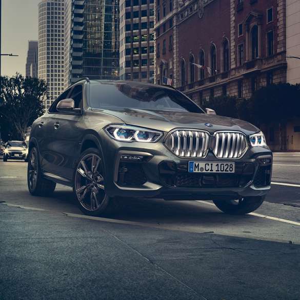 BMW X6, suspension M adaptative Professional G06. La BMW X6 vue de trois quarts avant devant un décor urbain G06.