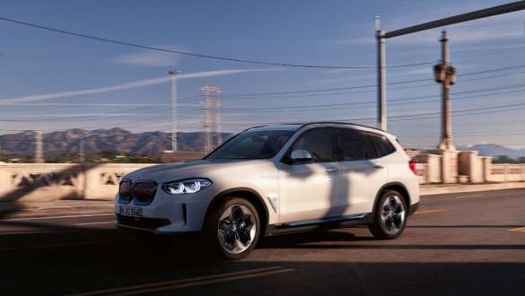 Suspension SelectDrive M BMW iX3 G08, en mouvement sur la route Suspension SelectDrive M BMW iX3 G08 2020 en Mineralweiß metallic, vue de trois quarts avant en mouvement sur la route