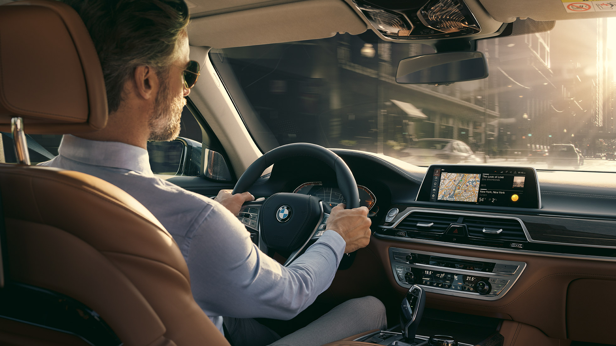 Fonctionnalités Connectivity de la BMW Série 7 G11 BMW Série 7 Berline : homme assis à bord de la BMW en train d’utiliser les fonctionnalités Connectivity G11