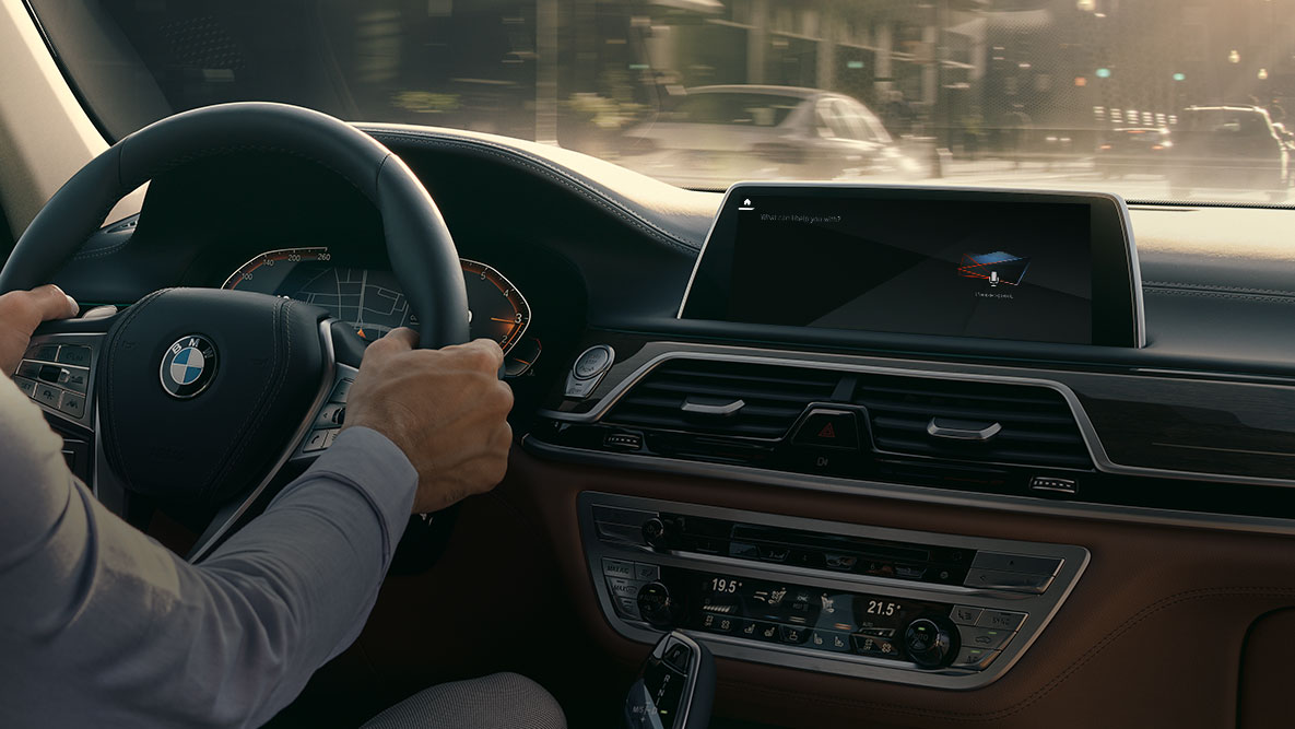 BMW Intelligent Personal Assistant BMW Intelligent Personal Assistant : homme en train de conduire une BMW, vue en gros plan du Live Cockpit Professional