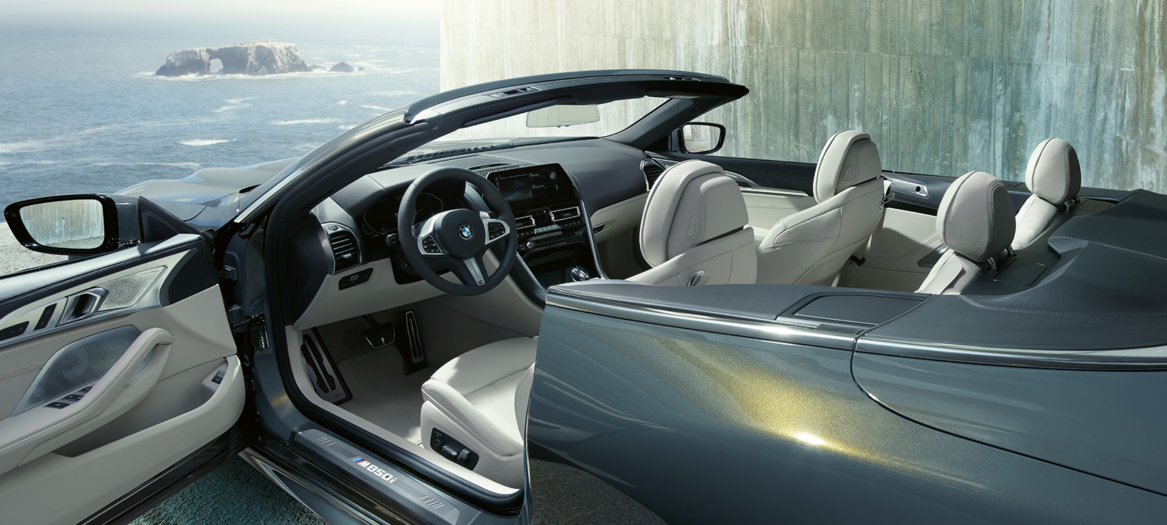 BMW M850i xDrive Dravitgrau metallic, vue de profil, capote en tissu et porte ouverte G14. BMW M850i xDrive Dravitgrau metallic, vue de profil, capote en tissu et porte ouverte G14.