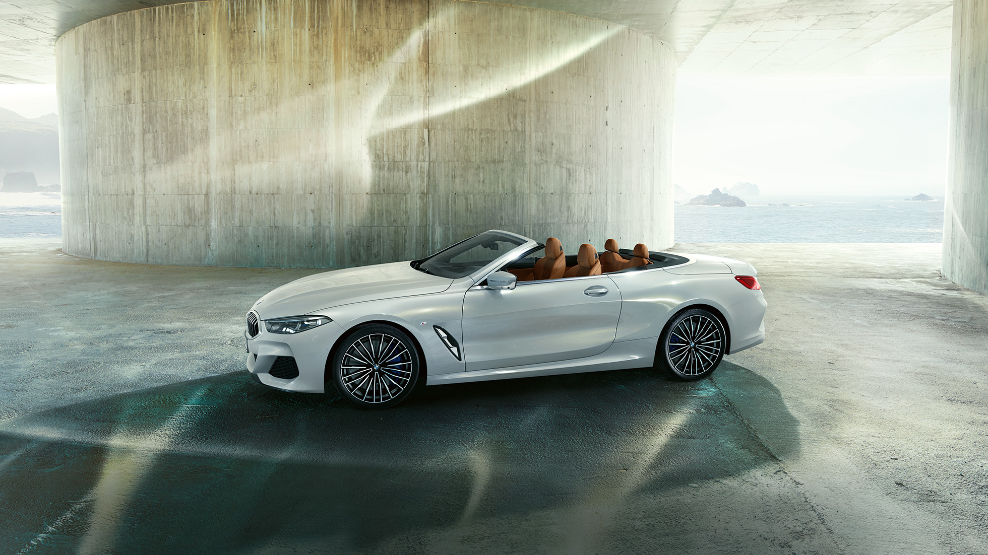 BMW M850i xDrive en Mineralweiß metallic, vue de profil avec capote souple ouverte G14. BMW M850i xDrive en Mineralweiß metallic, vue de profil avec capote souple ouverte G14.