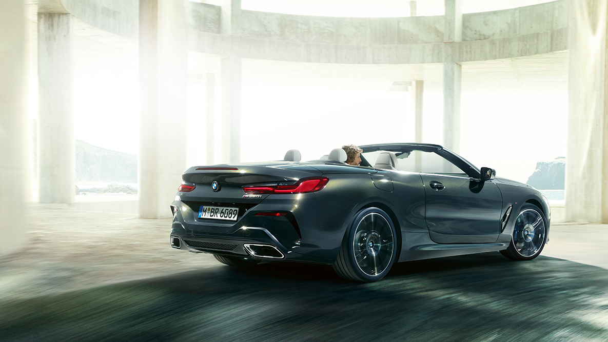 BMW M850i xDrive avec capote ouverte, sur la route, vue de profil. BMW M850i xDrive avec capote ouverte, sur la route, vue de profil.