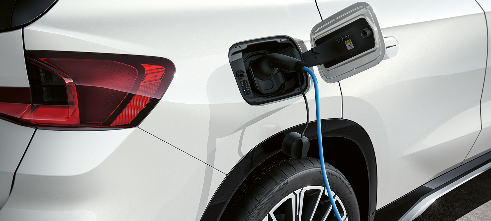 SUV compact électrique BMW iX1 U11 BEV 2022 Clapet de recharge SUV compact électrique BMW iX1 U11 BEV 2022 Mineralweiss metallisé clapet de recharge ouvert lors de la charge
