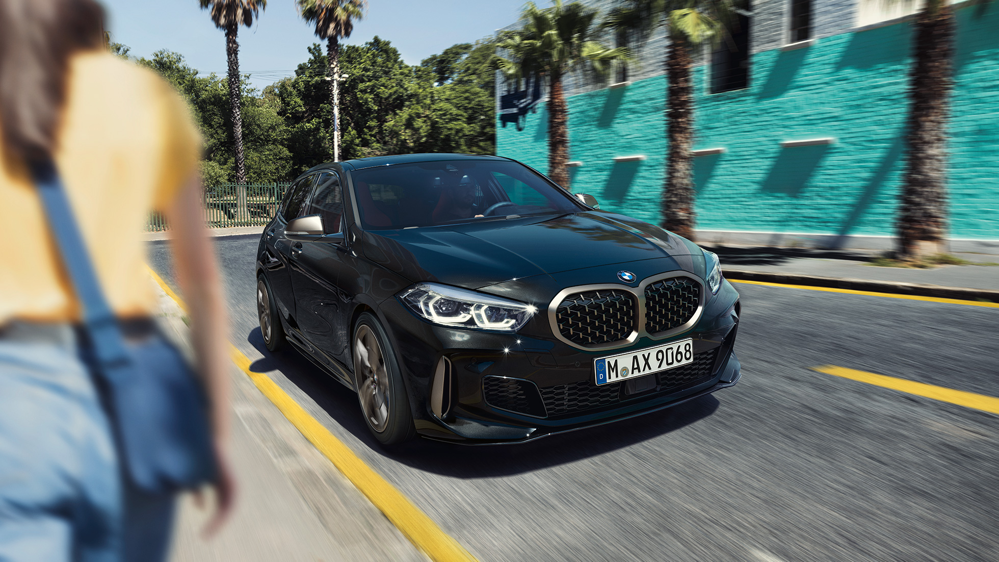 BMW M135i xDrive de face dans la rue en mouvement BMW M135i xDrive de face dans la rue en mouvement