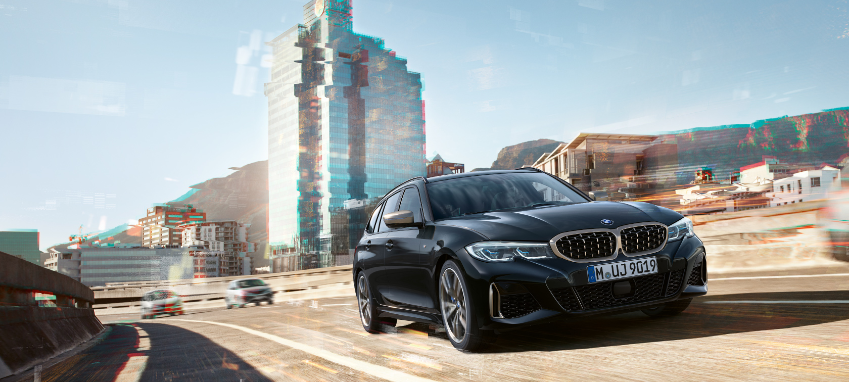 Vue de trois quarts avant dans un décor urbain BMW M340i xDrive Touring, vue de trois quarts avant dans un décor urbain