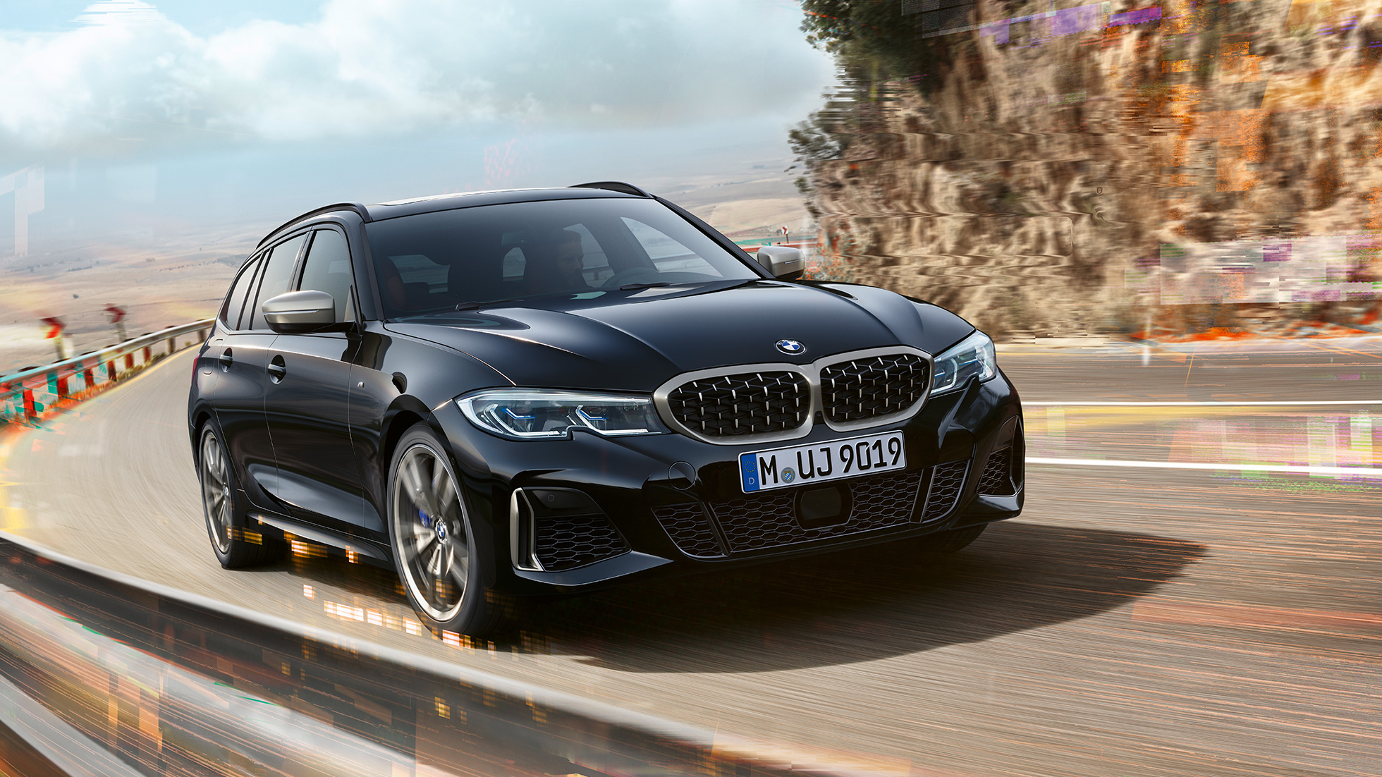BMW M340i xDrive Touring en dynamique sur une route de bord de mer BMW M340i xDrive Touring en dynamique sur une route de bord de mer