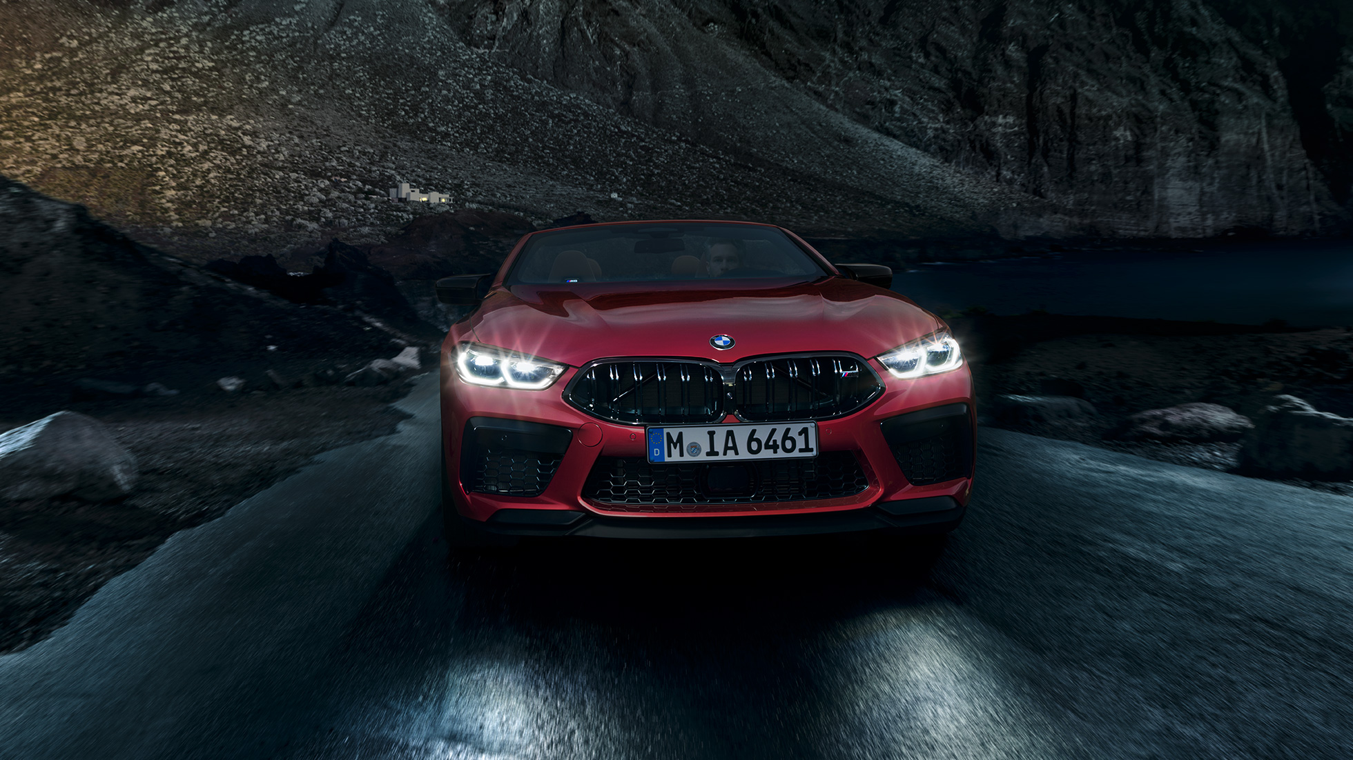 BMW M8 Competition Cabriolet, vue avant F91. BMW M8 Competition Cabriolet en Motegi Rot metallic avec phares allumés, vue avant, en conduite de nuit F91.