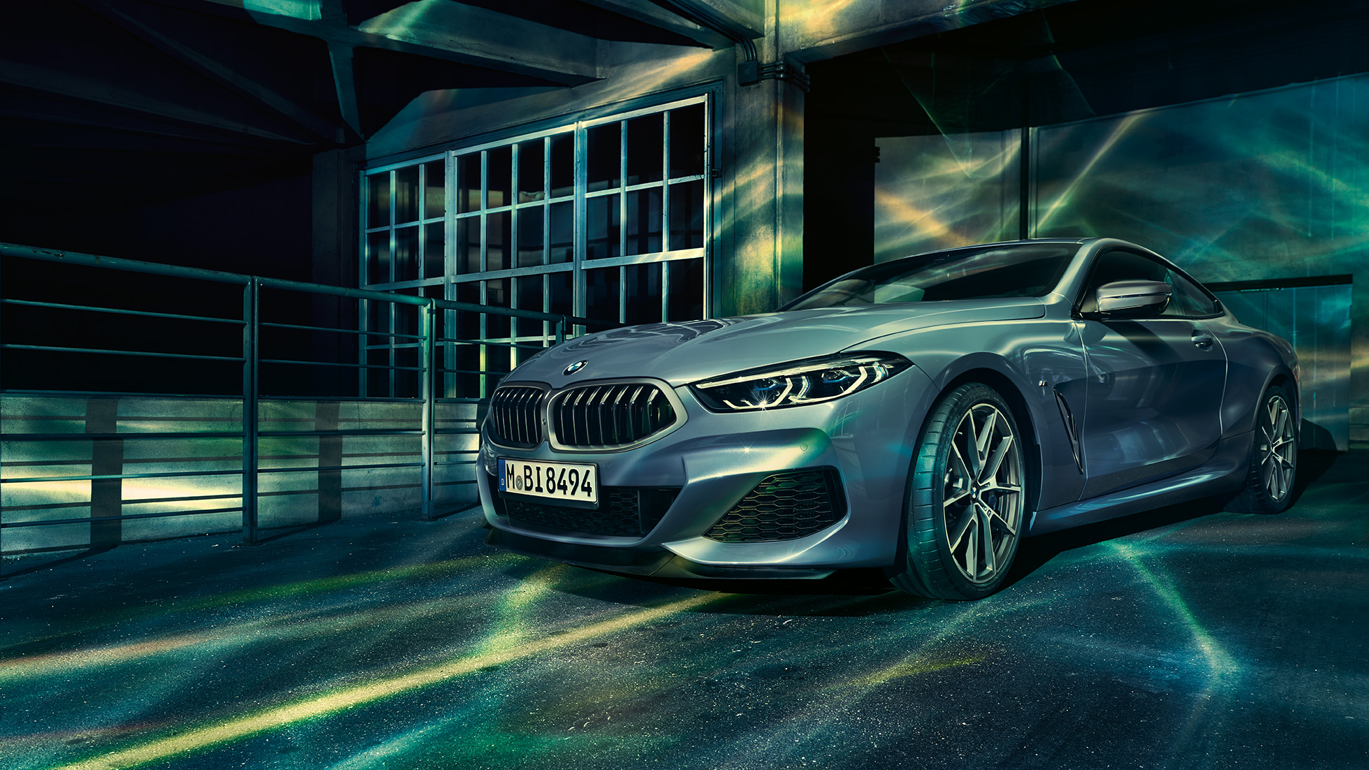 BMW M850i xDrive Coupé, vue de trois quarts avant G15. BMW M850i xDrive Coupé en Barcelona Blau metallic, vue de trois quarts avant à l’arrêt devant un immeuble G15.