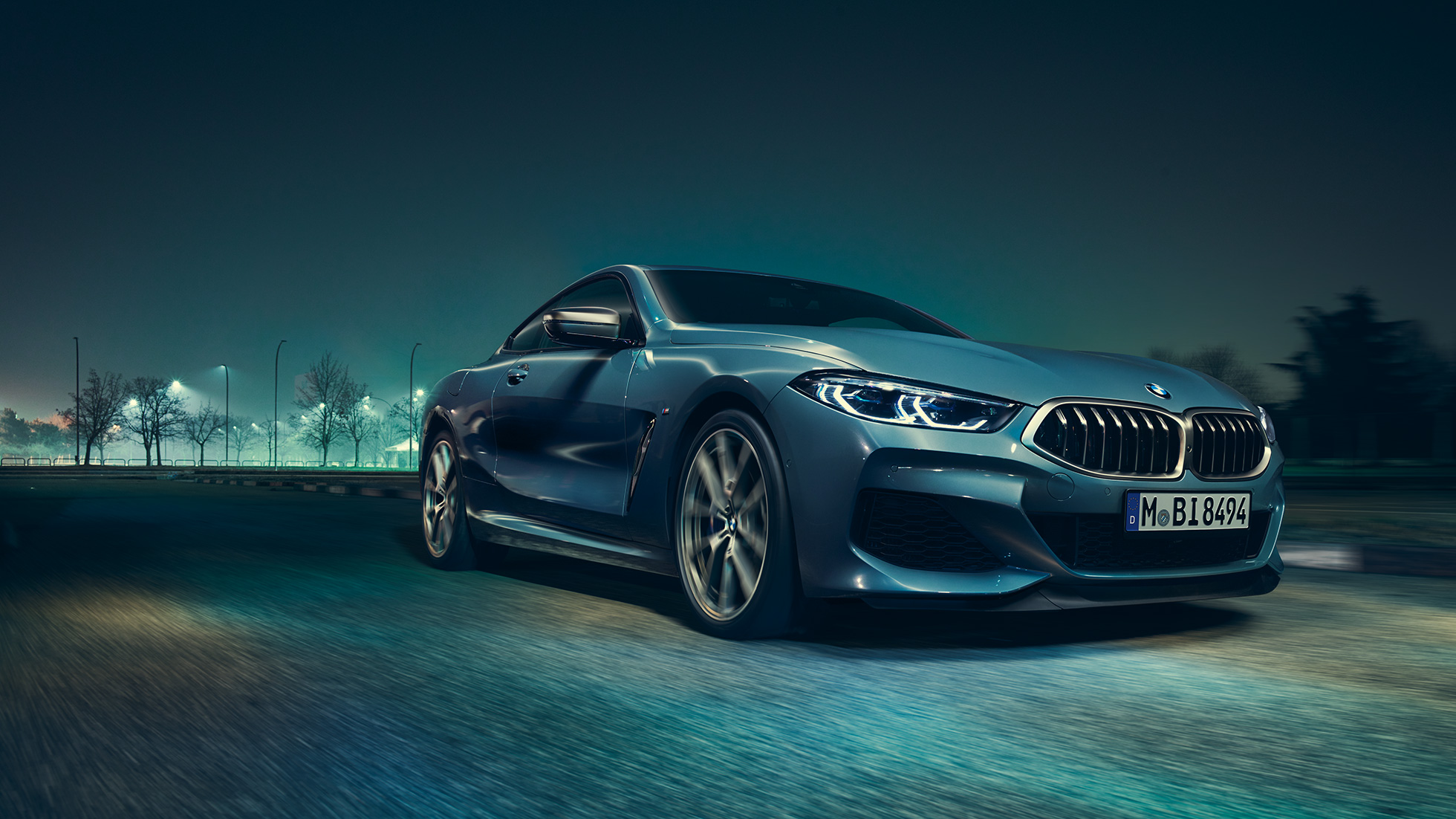 BMW M850i xDrive Coupé, vue de trois quarts avant gauche G15. BMW M850i xDrive Coupé en Barcelona Blau metallic, vue de trois quarts avant gauche, en marche, de nuit G15.