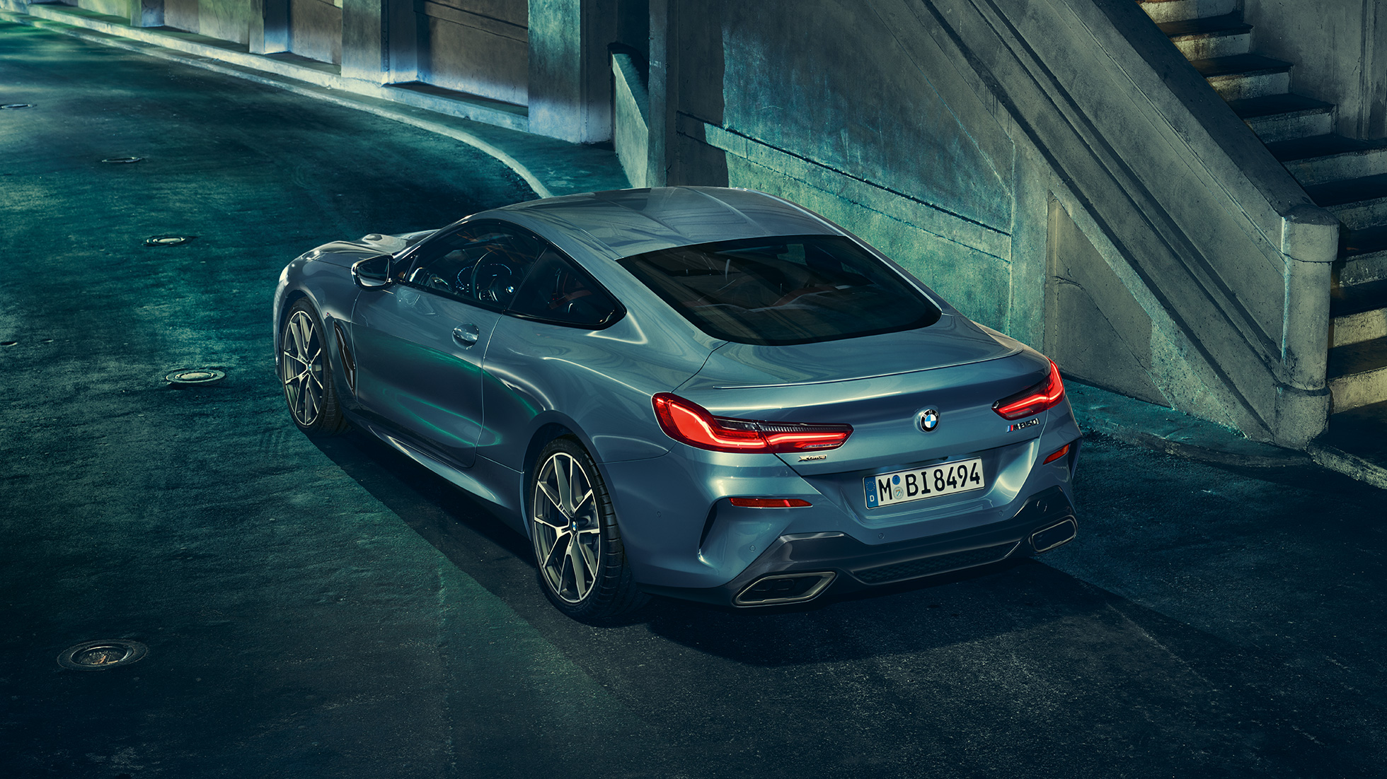 BMW M850i xDrive Coupé, vue de trois quarts arrière gauche G15. BMW M850i xDrive Coupé en Barcelona Blau metallic, vue de trois quarts arrière gauche, à l’arrêt, de nuit G15.
