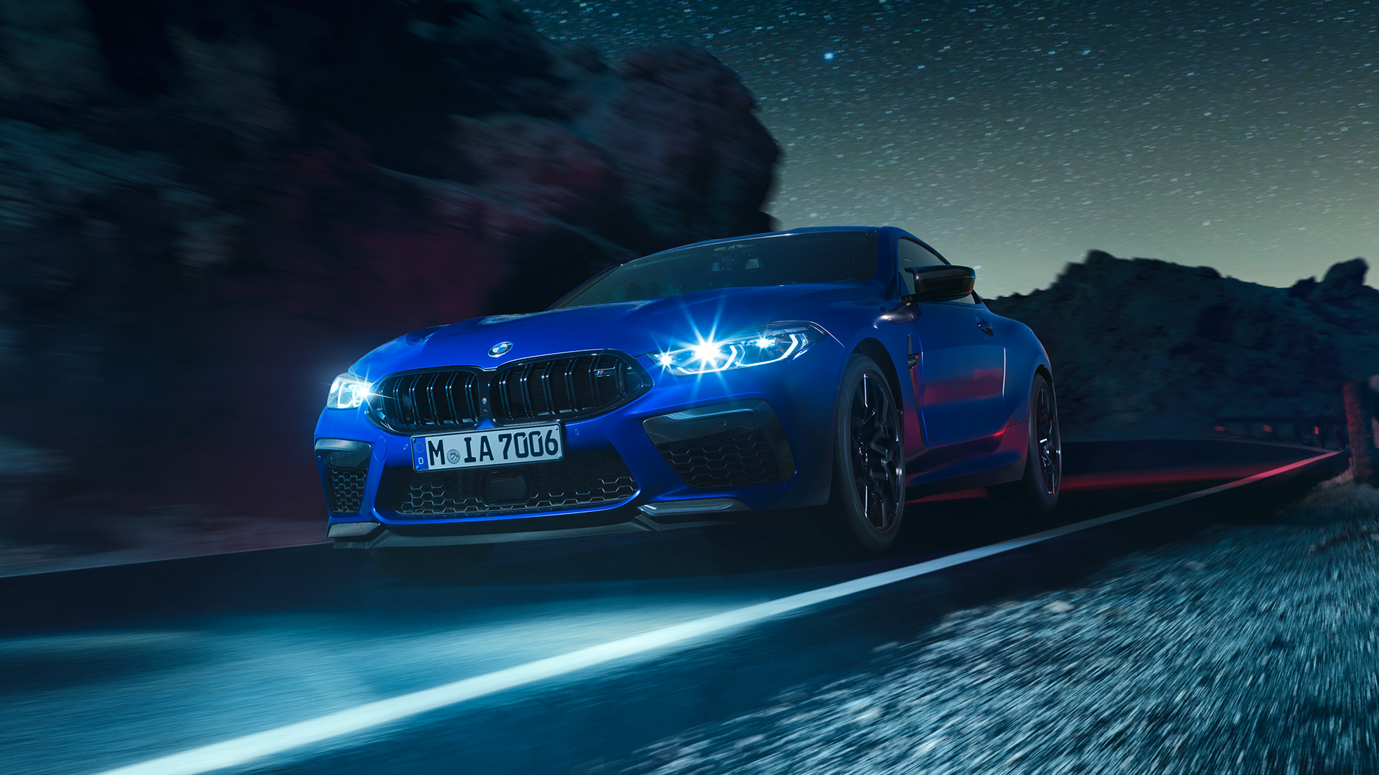 BMW M8 Competition Coupé en marche, vue de trois quarts avant F92. BMW M8 Competition Coupé en Marina Bay Blau metallic avec phares LED allumés, vue de trois quarts avant en marche, de nuit F92.