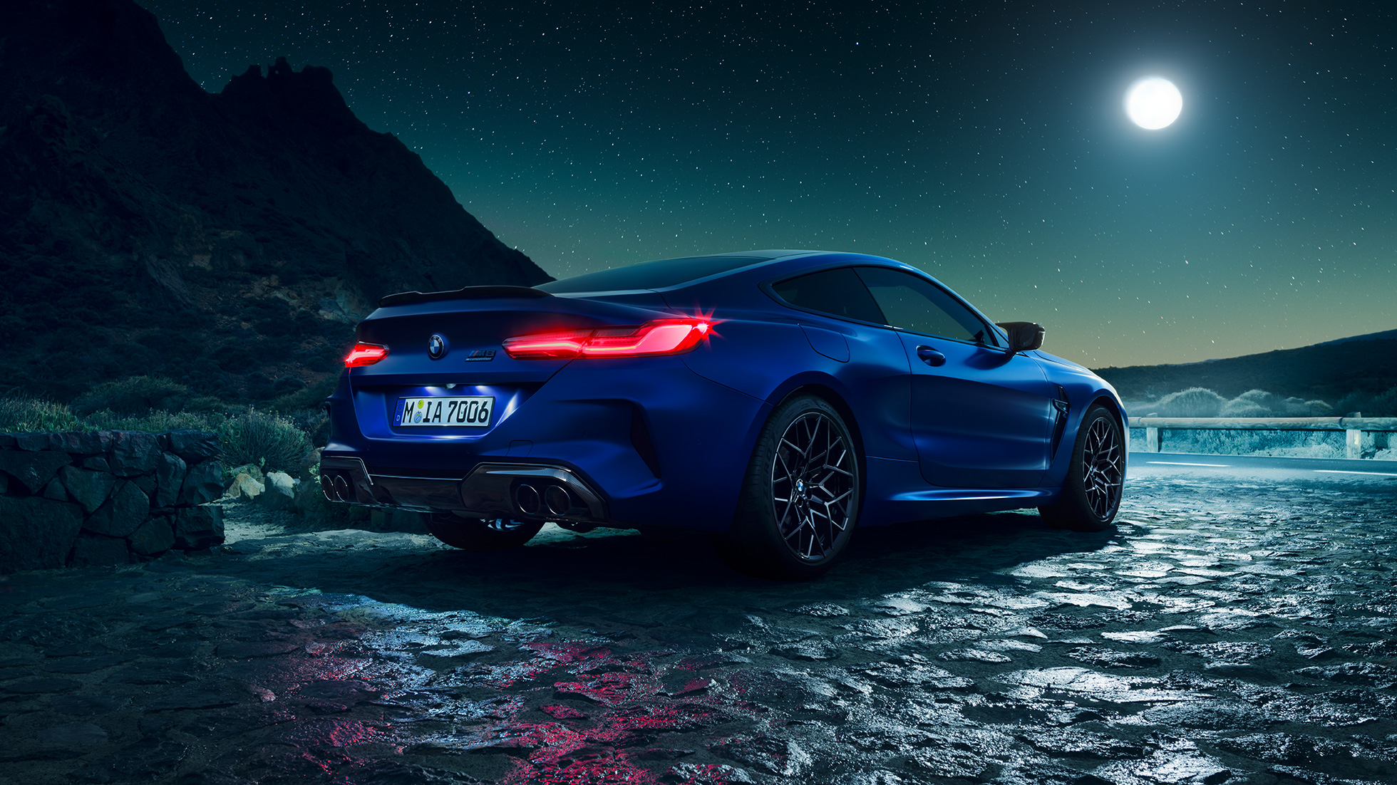 BMW M8 Competition, vue de trois quarts arrière F92. BMW M8 Competition Coupé en Marina Bay Blau metallic avec feux arrière LED allumés, vue de trois quarts arrière à l’arrêt, sous la pleine lune F92.