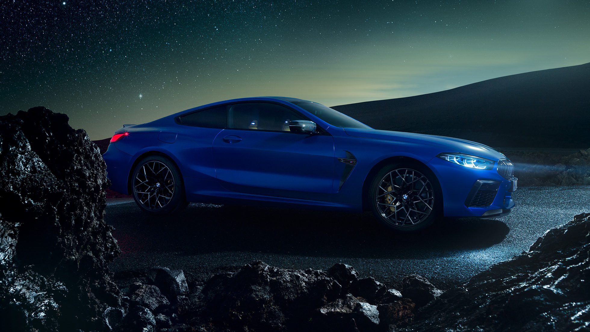 BMW M8 Competition Coupé bleue de nuit dans un paysage volcanique BMW M8 Competition Coupé bleue de nuit dans un paysage volcanique