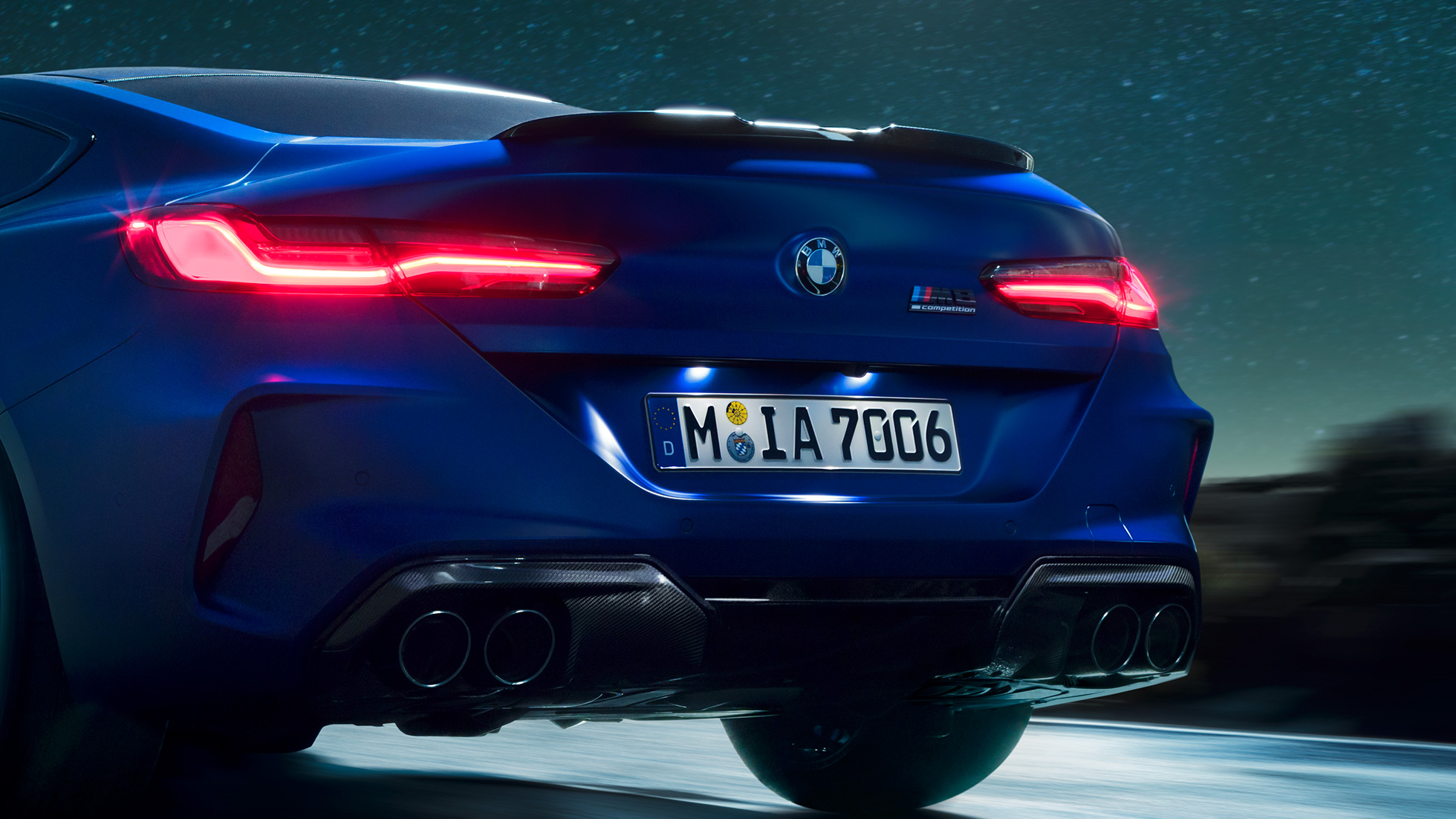 Diffuseur M en Carbon Schwarz F92. BMW M8 Competition Coupé en Marina Bay Blau metallic, vue en gros plan de la poupe de nuit, avec diffuseur M en Carbon Schwarz F92.