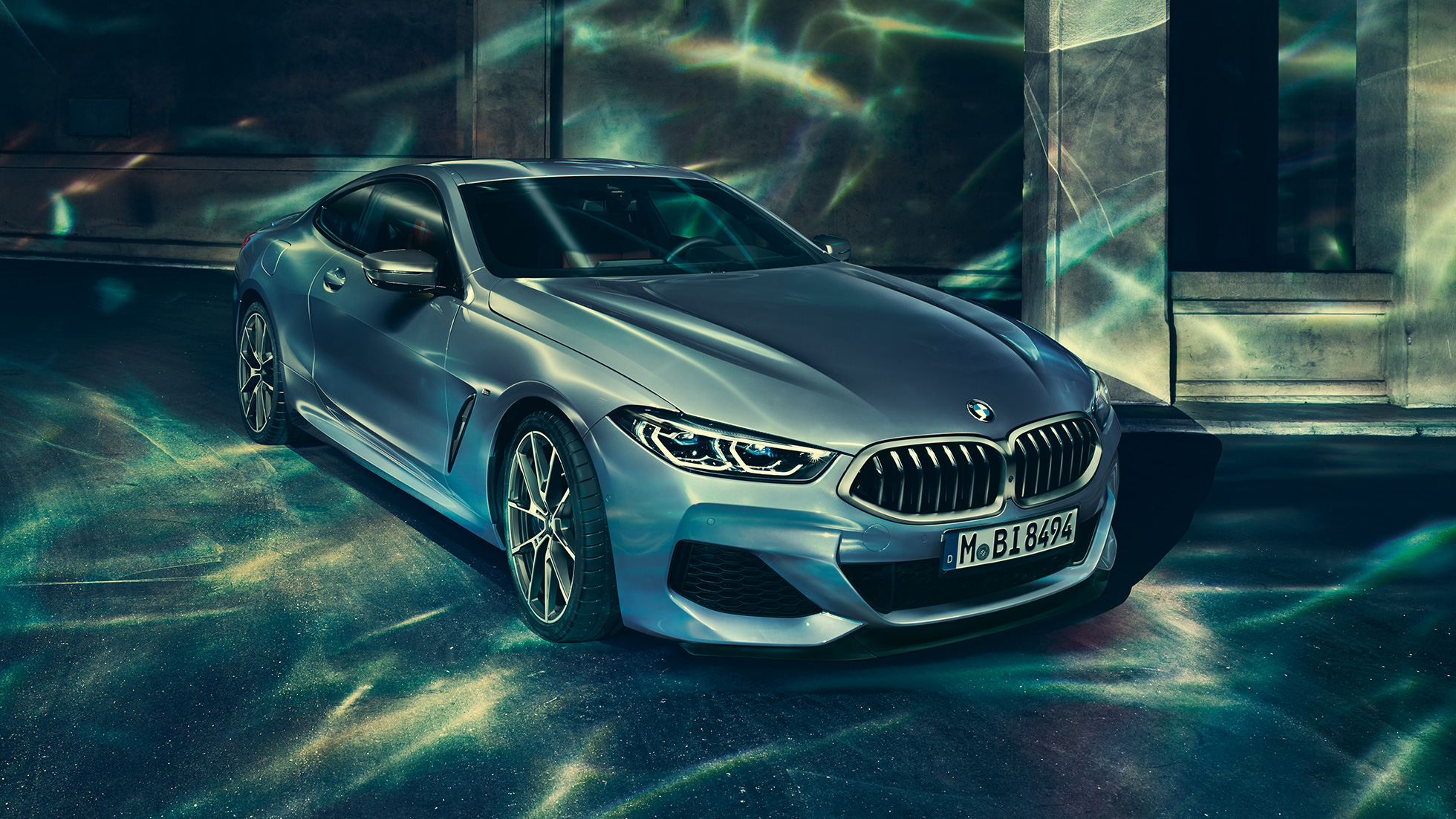 BMW M850i xDrive Coupé, vue de trois quarts avant gauche G15. BMW M850i xDrive Coupé en Barcelona Blau metallic, vue de trois quarts avant gauche, à l’arrêt devant un immeuble G15.
