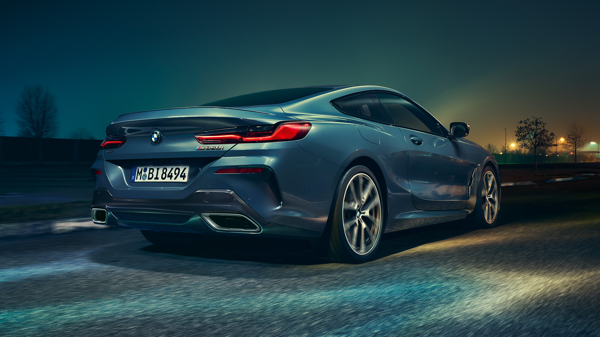 BMW M850i xDrive Coupé, vue arrière G15. BMW M850i xDrive Coupé en Barcelona Blau metallic en marche, vue nocturne arrière G15.