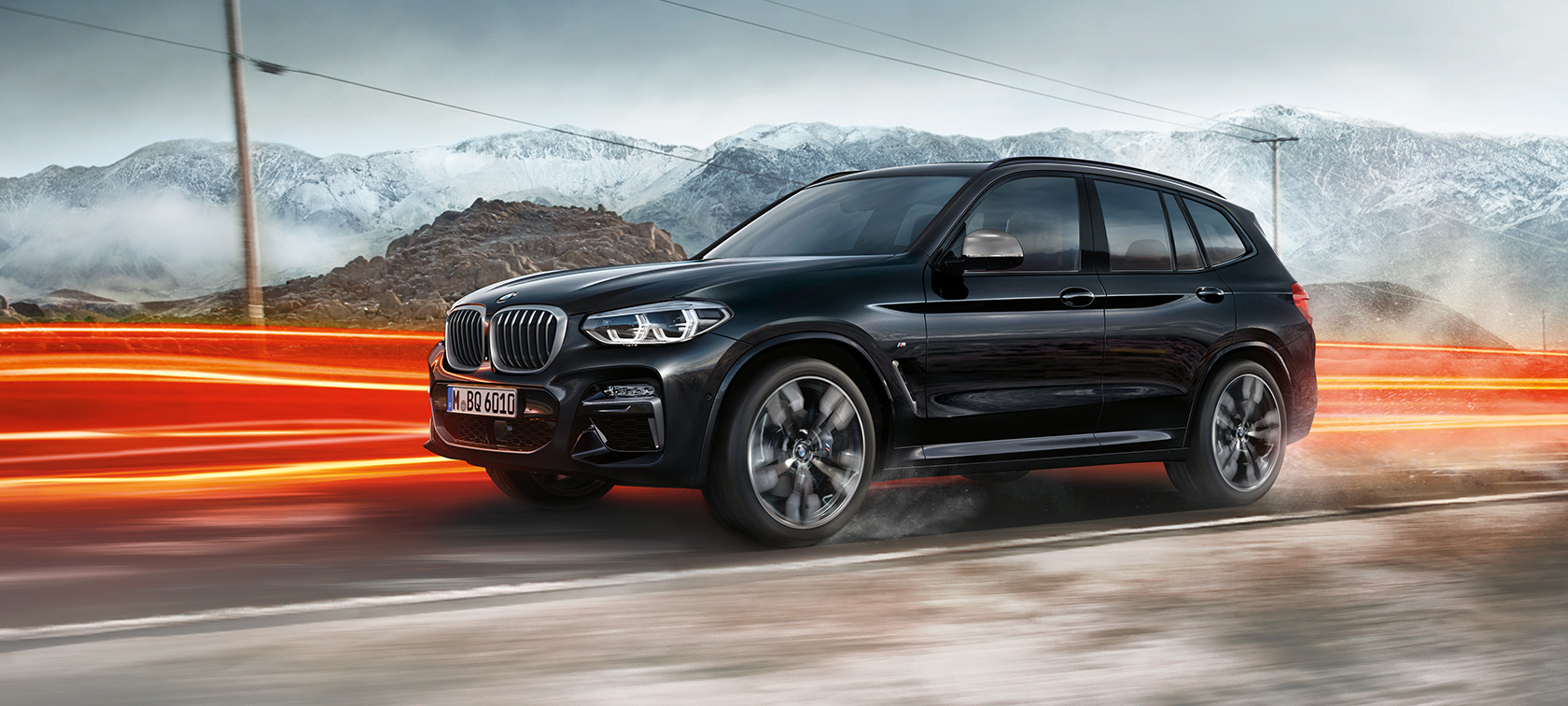 BMW X3 M40i et BMW X3 M40d, vue de profil Extérieur des BMW X3 M40i et BMW X3 M40d en Saphierschwarz metallic, en mouvement, vue de profil devant un paysage montagneux avec bandes lumineuses