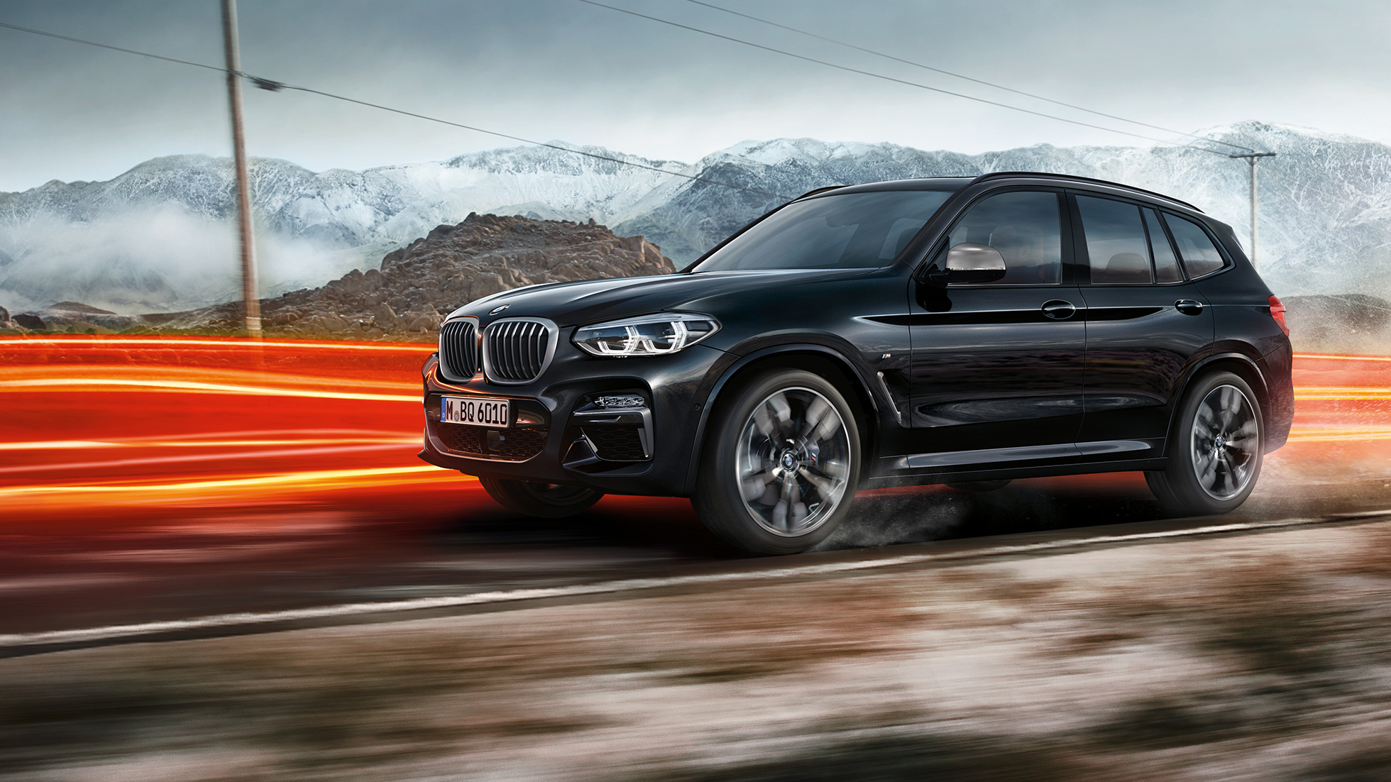 BMW X3 M40i et BMW X3 M40d, vue de profil Extérieur des BMW X3 M40i et BMW X3 M40d en Saphierschwarz metallic, en mouvement, vue de profil devant un paysage montagneux avec bandes lumineuses