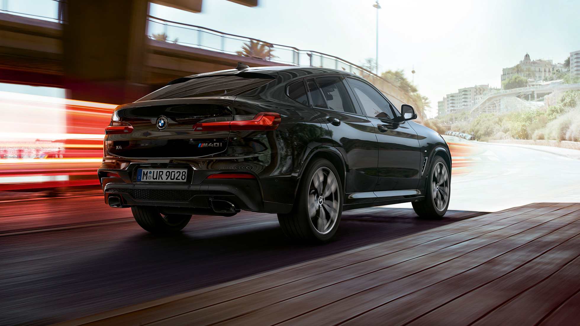 BMW X4 M40i, vue de trois quarts arrière G02. Extérieur de la BMW X4 M40i en Saphierschwarz metallic, vue de trois quarts arrière droite avec bandes lumineuses G02.