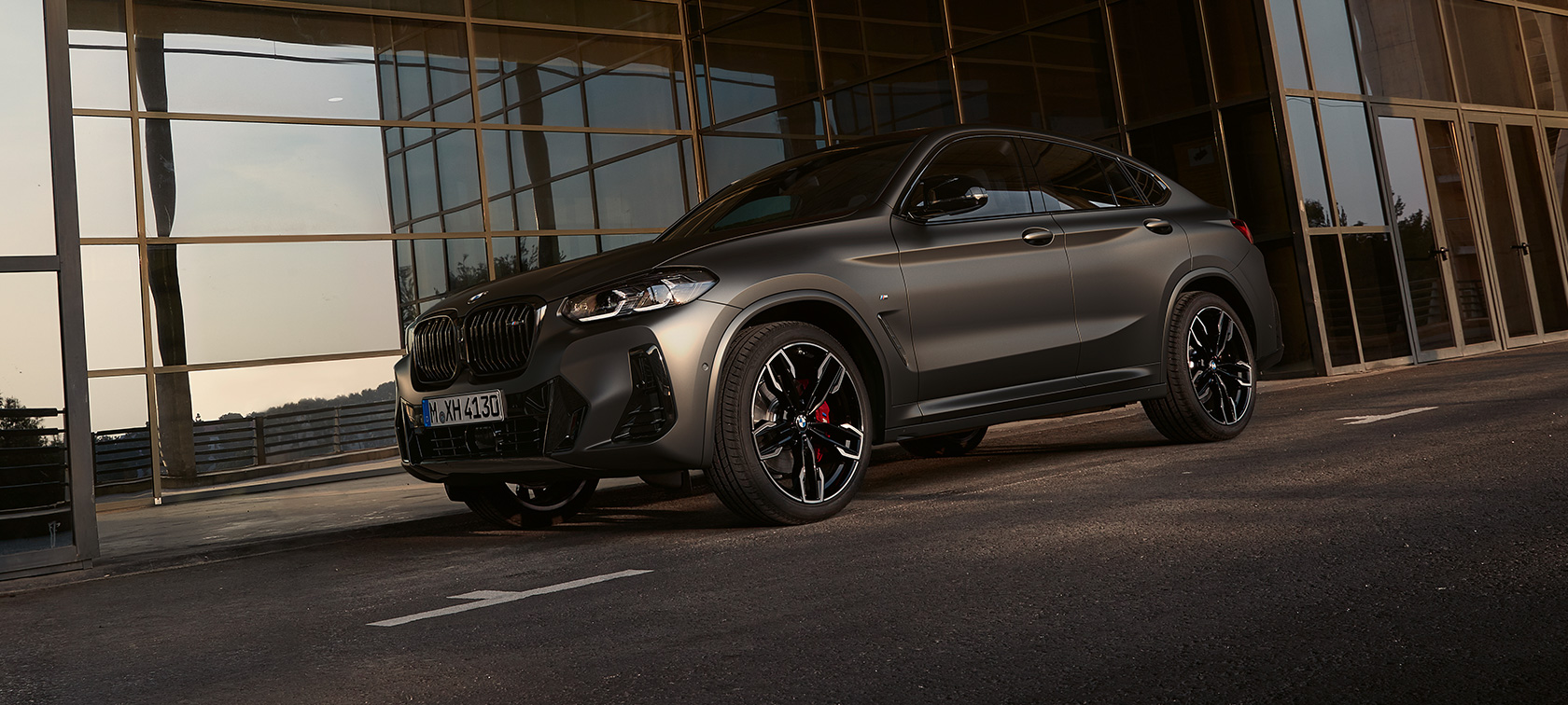 BMW X4 M40i G02 LCI 2021 Facelift vue de trois quarts avant devant une façade en verre