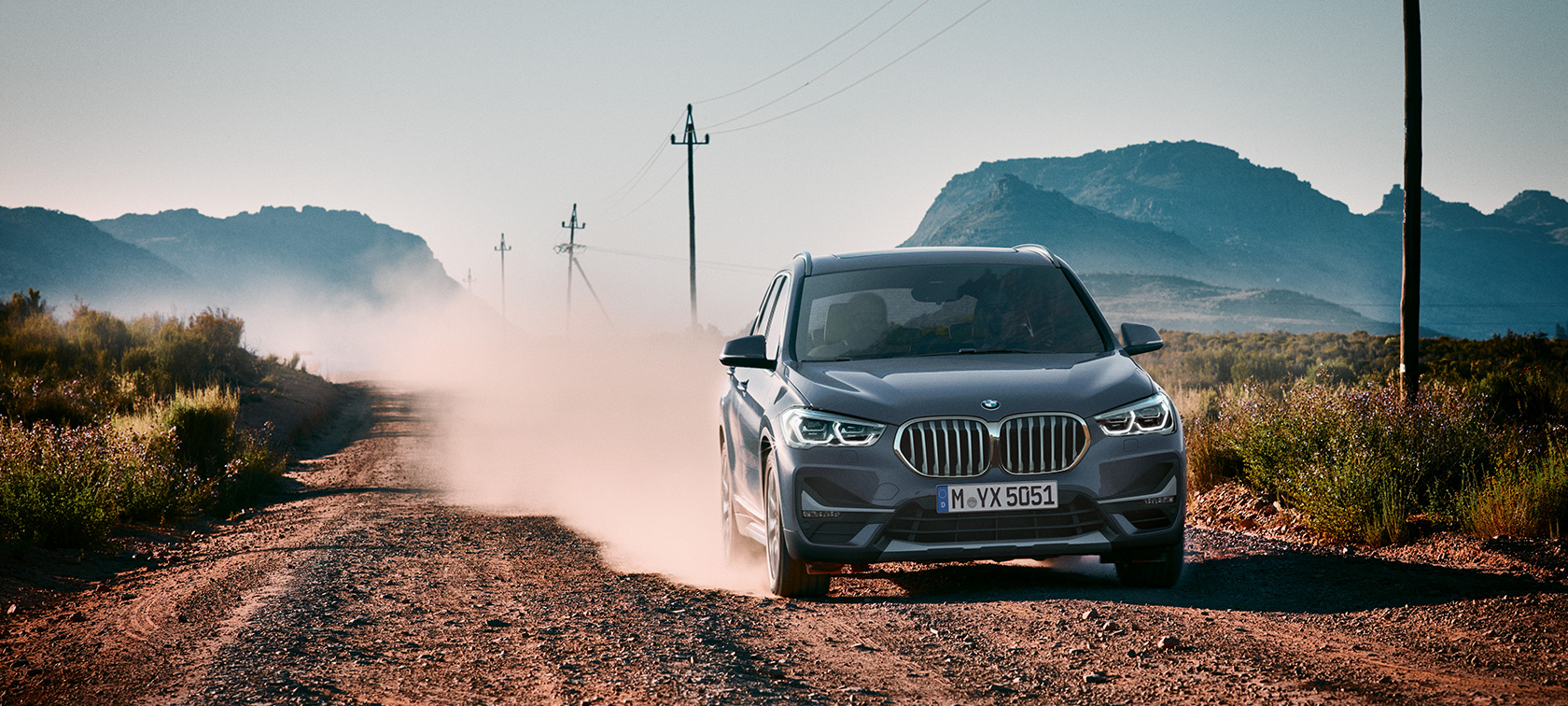 BMW X1, vue de trois quarts arrière F48. BMW X1, vue de trois quarts arrière devant le paysage montagneux F48.