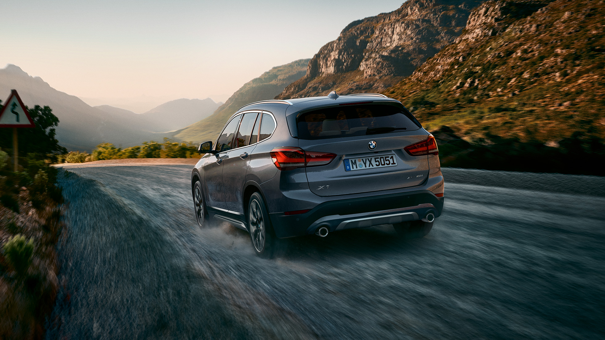 BMW X1, vue de trois quarts arrière F48. BMW X1, vue de trois quarts arrière devant le paysage montagneux F48.