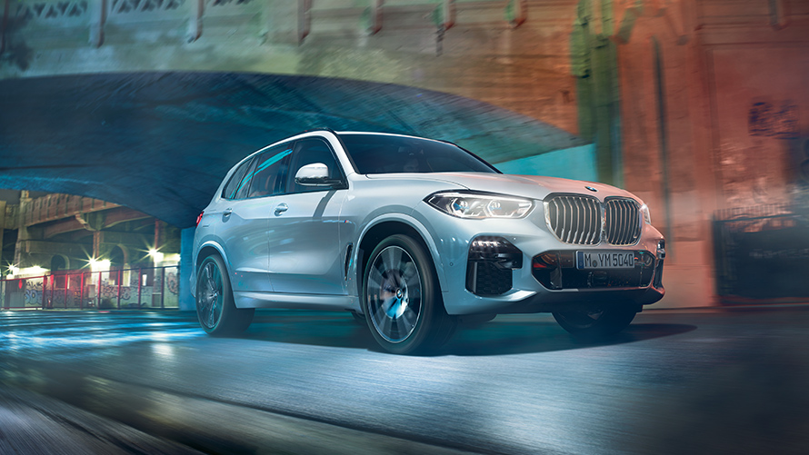 BMW X5 Hybride Rechargeable blanc en dynamique sous un pont BMW X5 Hybride Rechargeable blanc en dynamique sous un pont