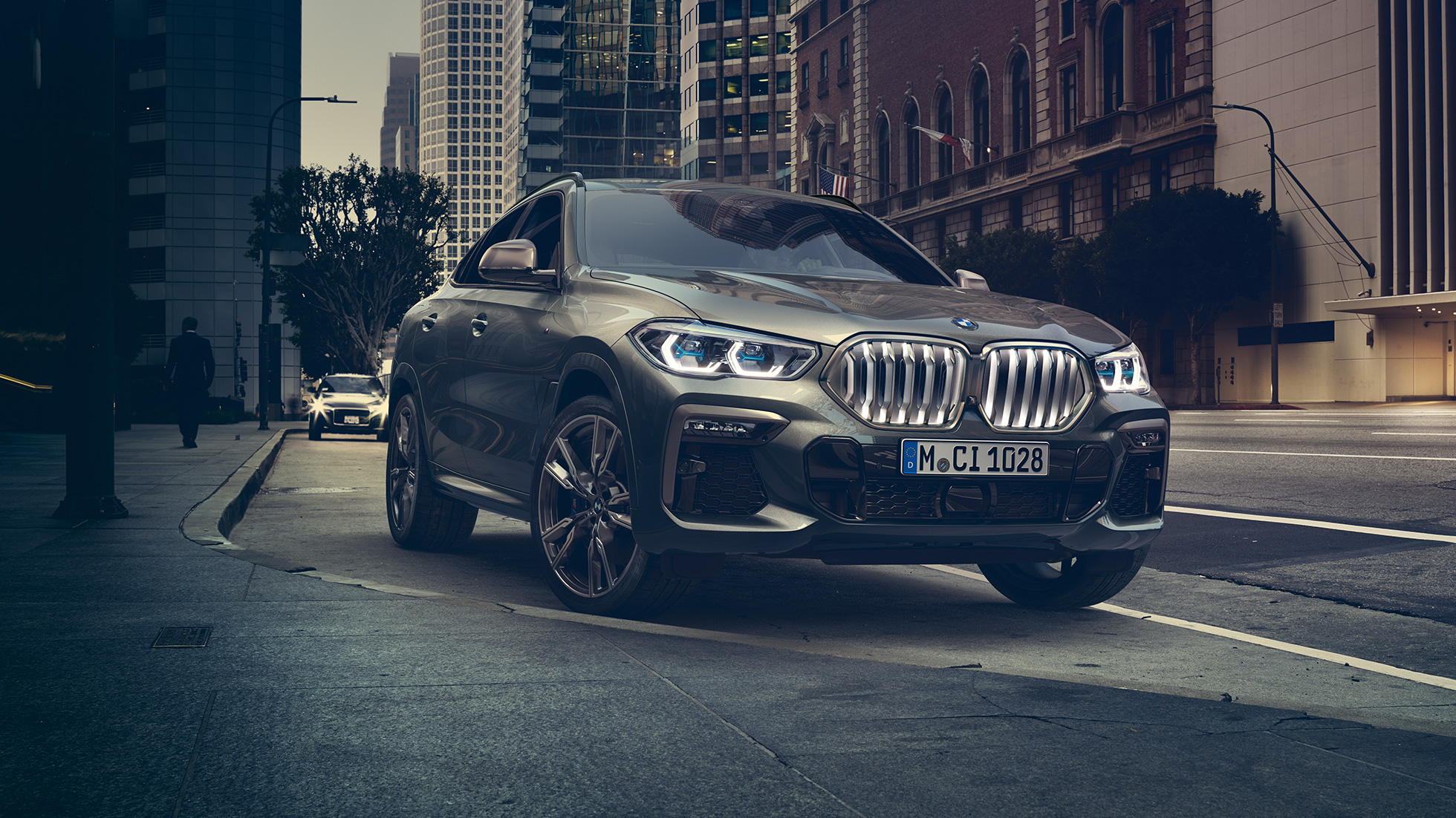 BMW X6, suspension M adaptative Professional G06. La BMW X6 vue de trois quarts avant devant un décor urbain G06.