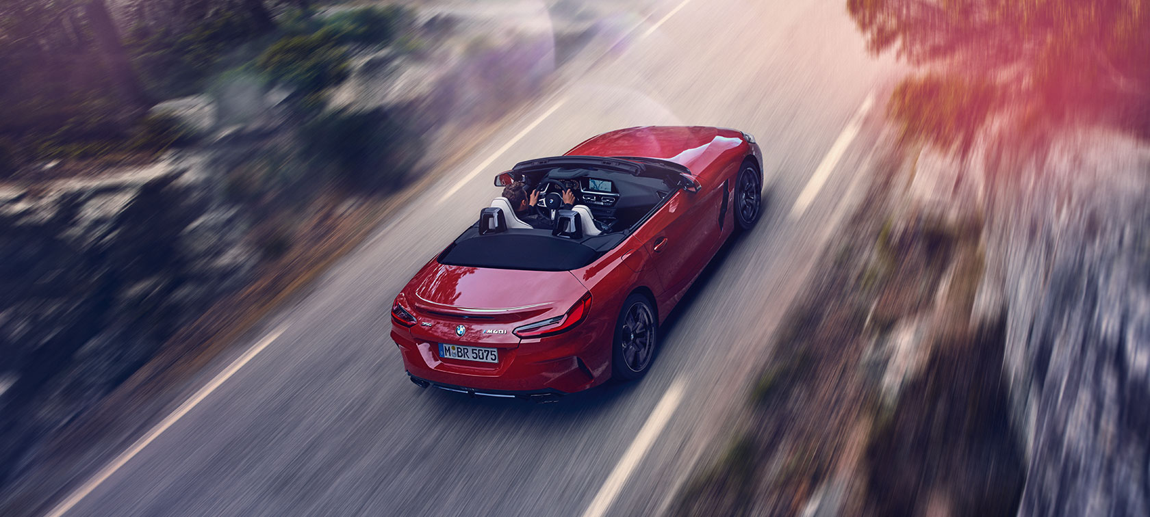 Vue en plongée d’une BMW Z4 Roadster G29 BMW Z4 (G29) San Francisco rot metallisé, vue du dessus, conduite sur route de montagne. G29