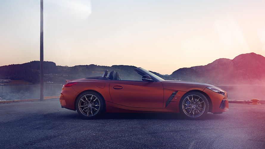 Orange BMW Z4 First Edition à l'arrêt dans un virage G29 BMW Z4 First Edition orange à l'arrêt dans un virage, paysage de montagnes G29