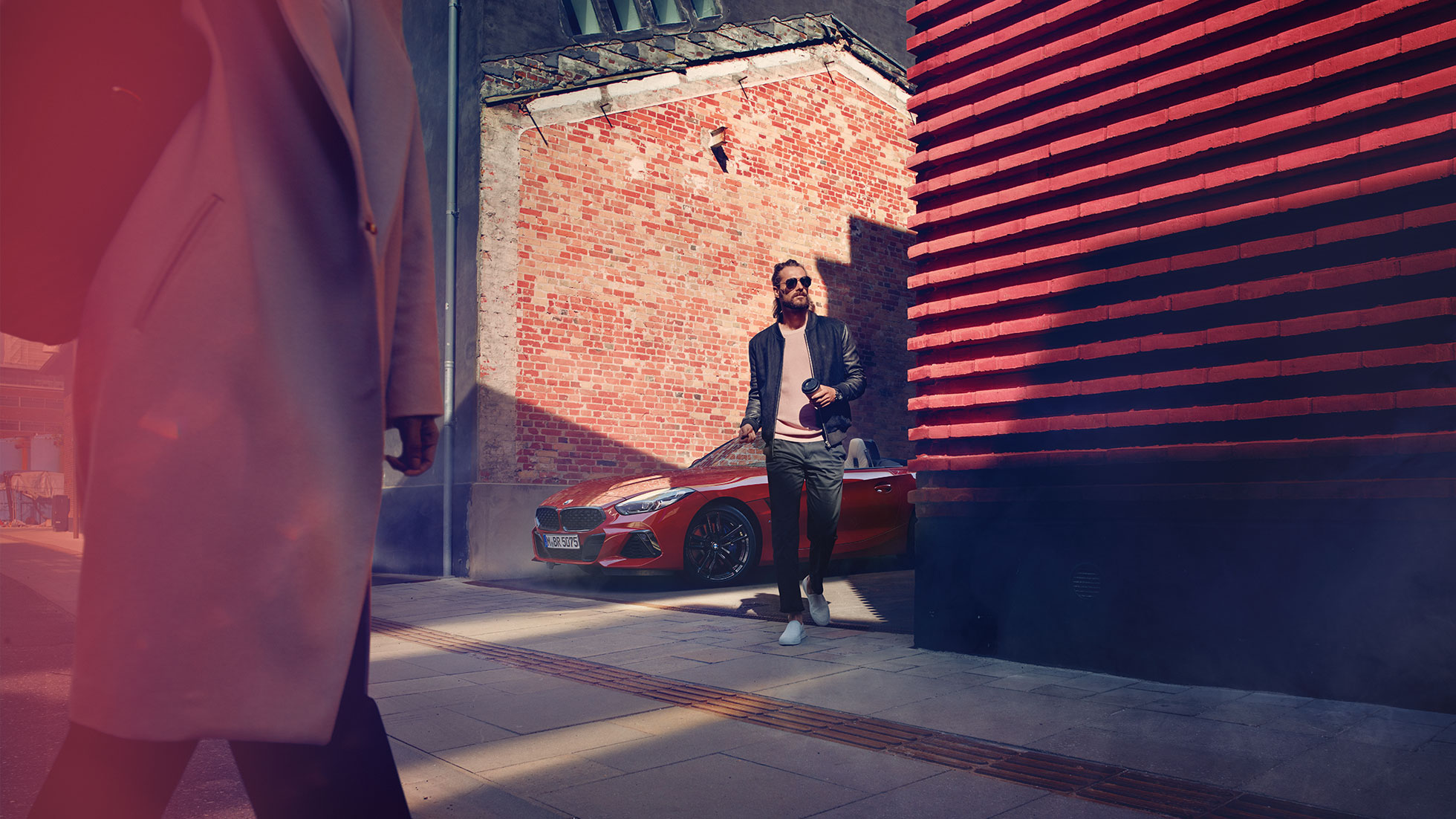 La BMW Z4 Roadster dans une rue latérale G29 Homme dans une rue latérale devant la BMW Z4 Roadster G29