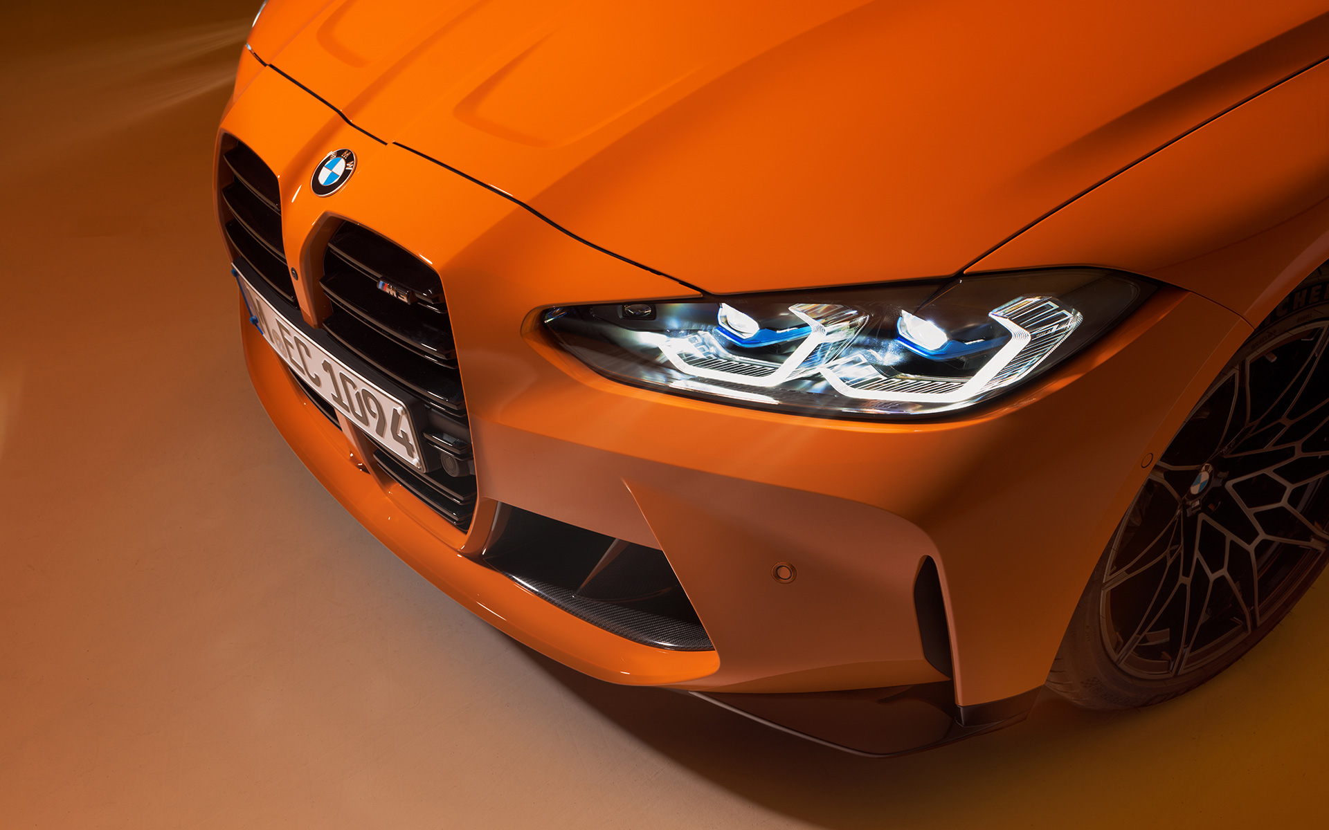 BMW M4 Competition Coupé G82 2021 BMW Individual Feuerorange vue de trois quarts face BMW M4 Competition Coupé G82 2021 BMW Individual Feuerorange à l’arrêt vue de trois quarts face en gros plan perspective aérienne