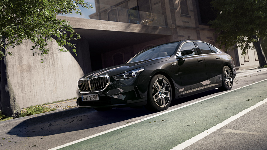 BMW Série 5 Berline G60 Vue de face 3/4 à l'arrêt devant une maison