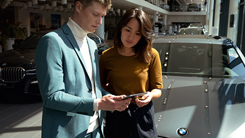 Situation de conseil BMW avec deux personnes devant un véhicule BMW