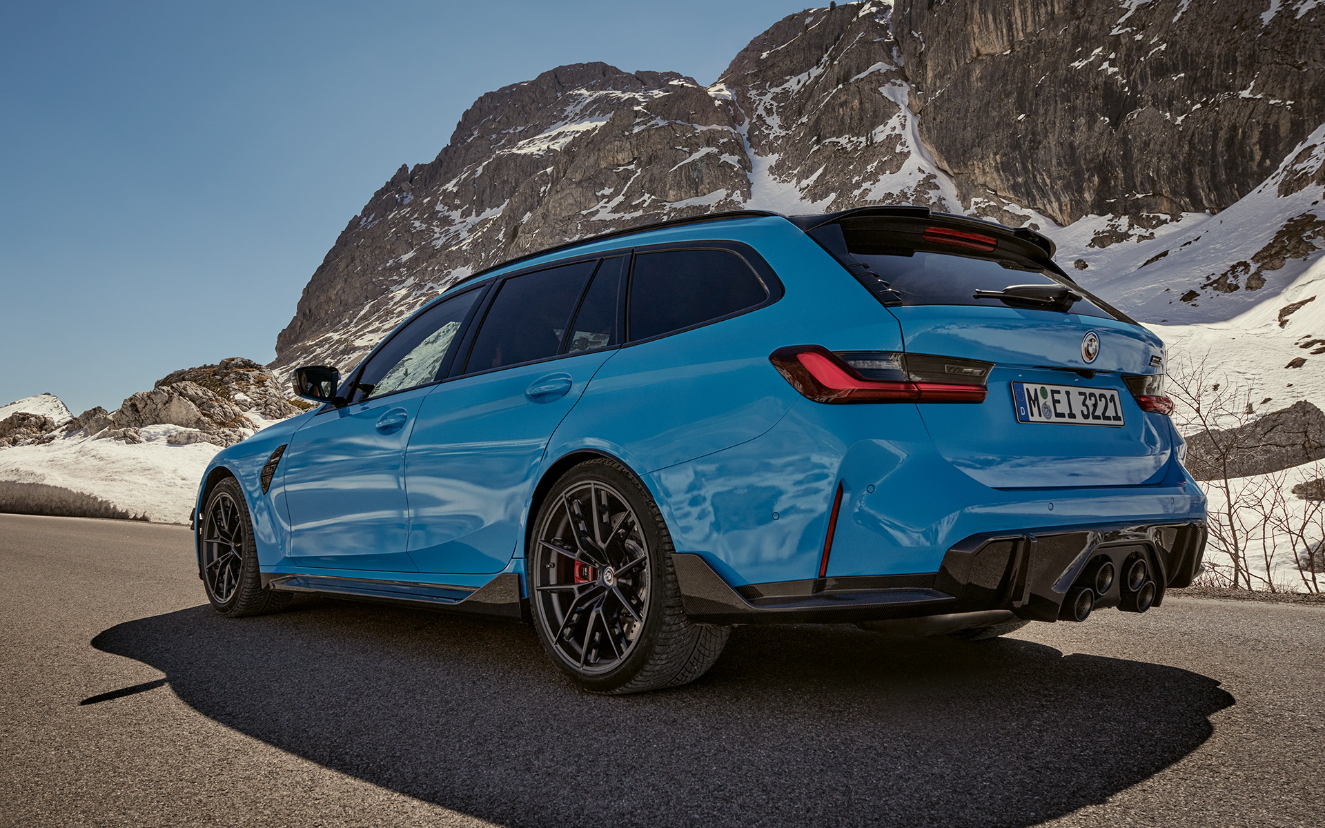 Accessoires BMW M3 Touring G81 BMW M Performance vue de trois quarts de profil en mouvement Accessoires BMW M3 Touring G81 BMW M Performance vue de trois quarts de profil en mouvement devant un paysage de montagnes