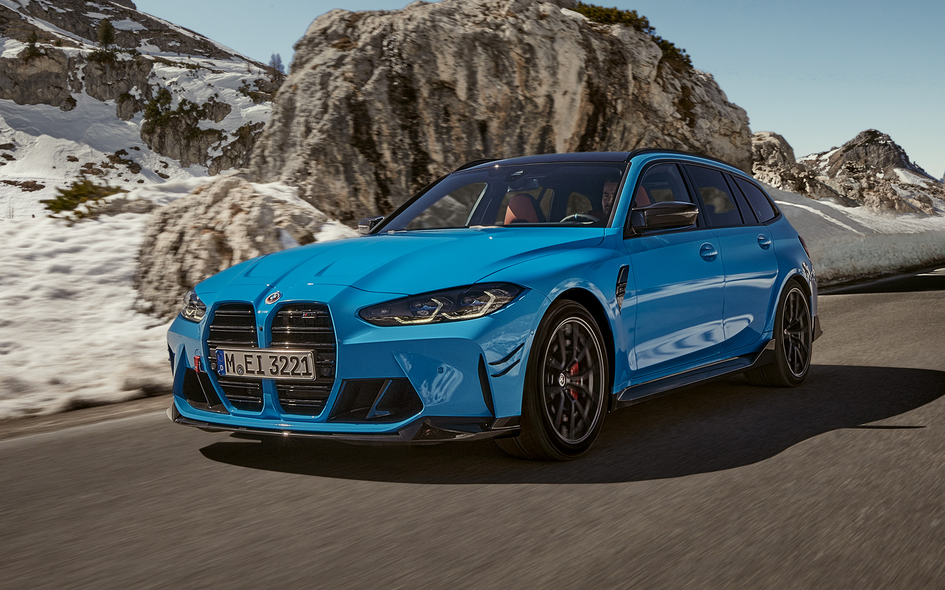Accessoires BMW M3 Touring G81 BMW M Performance vue de trois quarts avant en mouvement Accessoires BMW M3 Touring G81 BMW M Performance vue de trois quarts avant en mouvement devant un paysage de montagnes