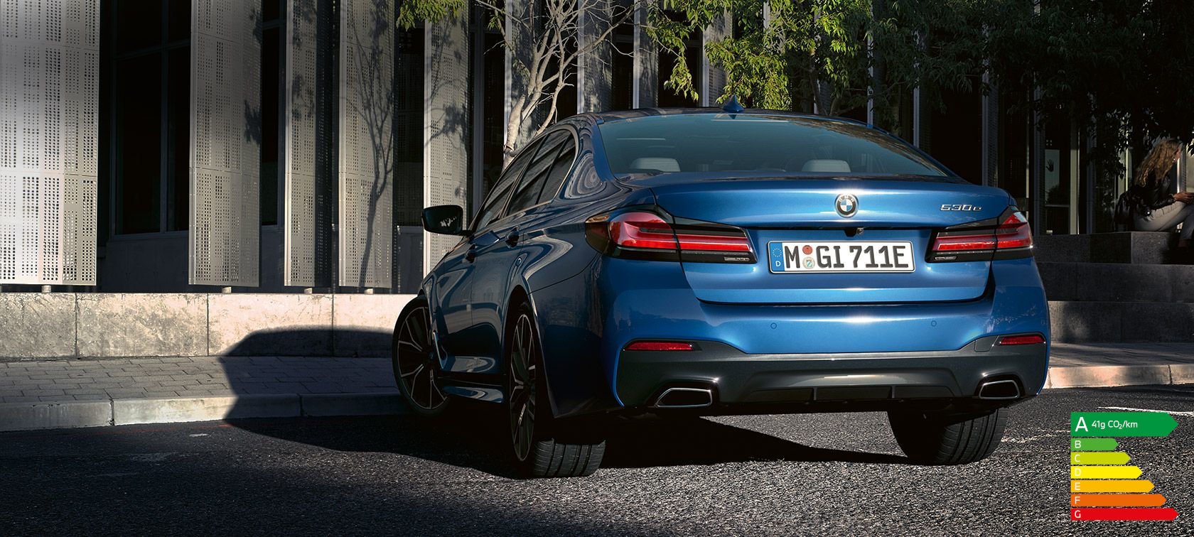 BMW Série 5 Berline eDrive (G30), Phytonicblau metallic, vue arrière devant un bâtiment