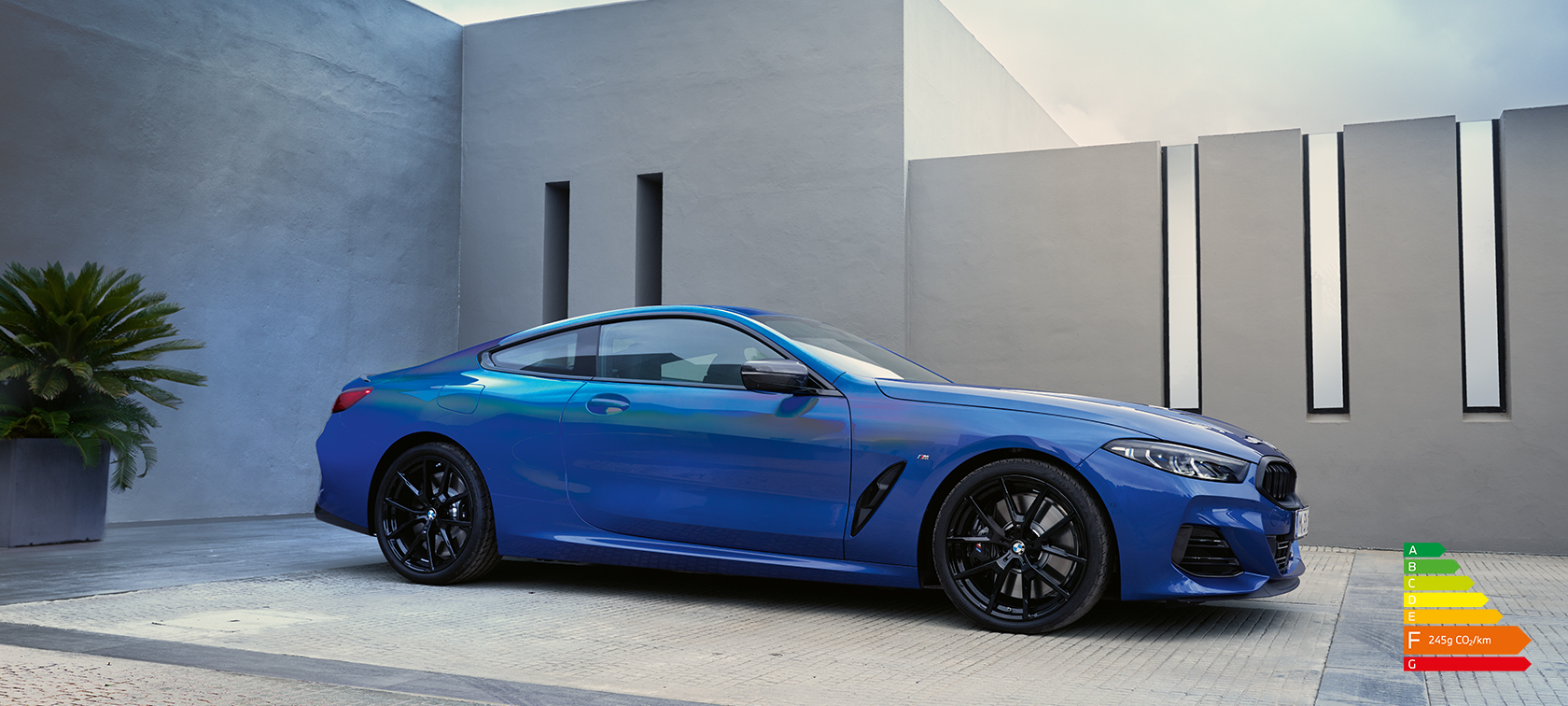 BMW Série 8 Coupé G15 LCI restylage 2022 M Portimao Blau metallic vue de profil en stationnement devant un mur