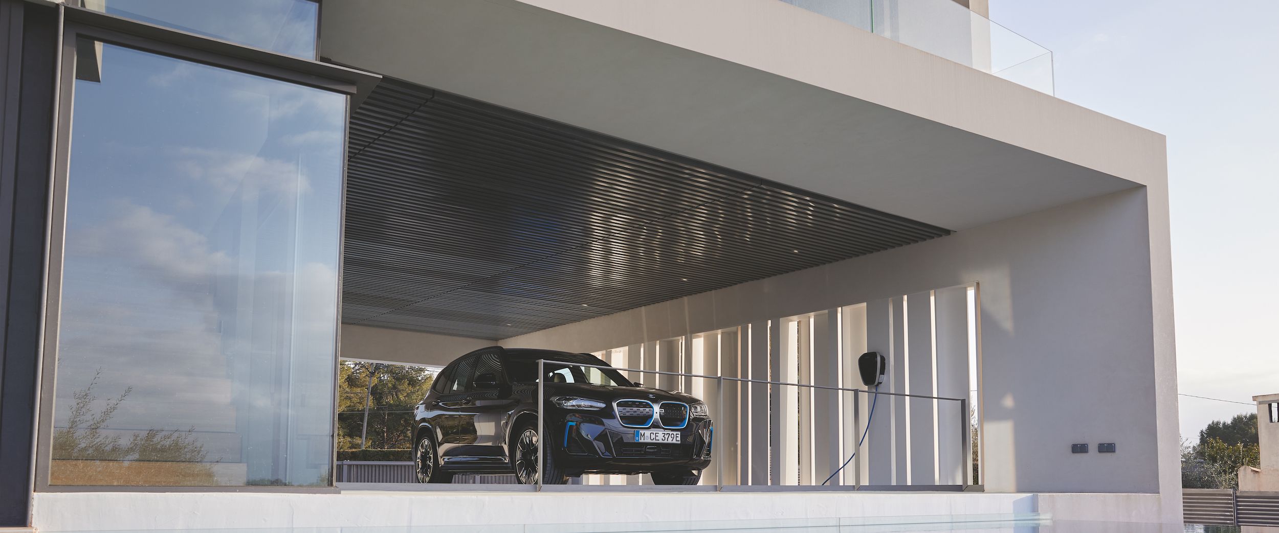 Voiture BMW iX3 en train de charger via une borne électrique Wallbox