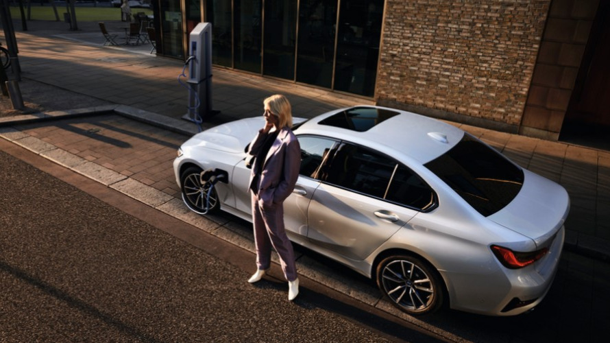 BMW Série 3 Berline blanche d'occasion, borne de recharge, garée