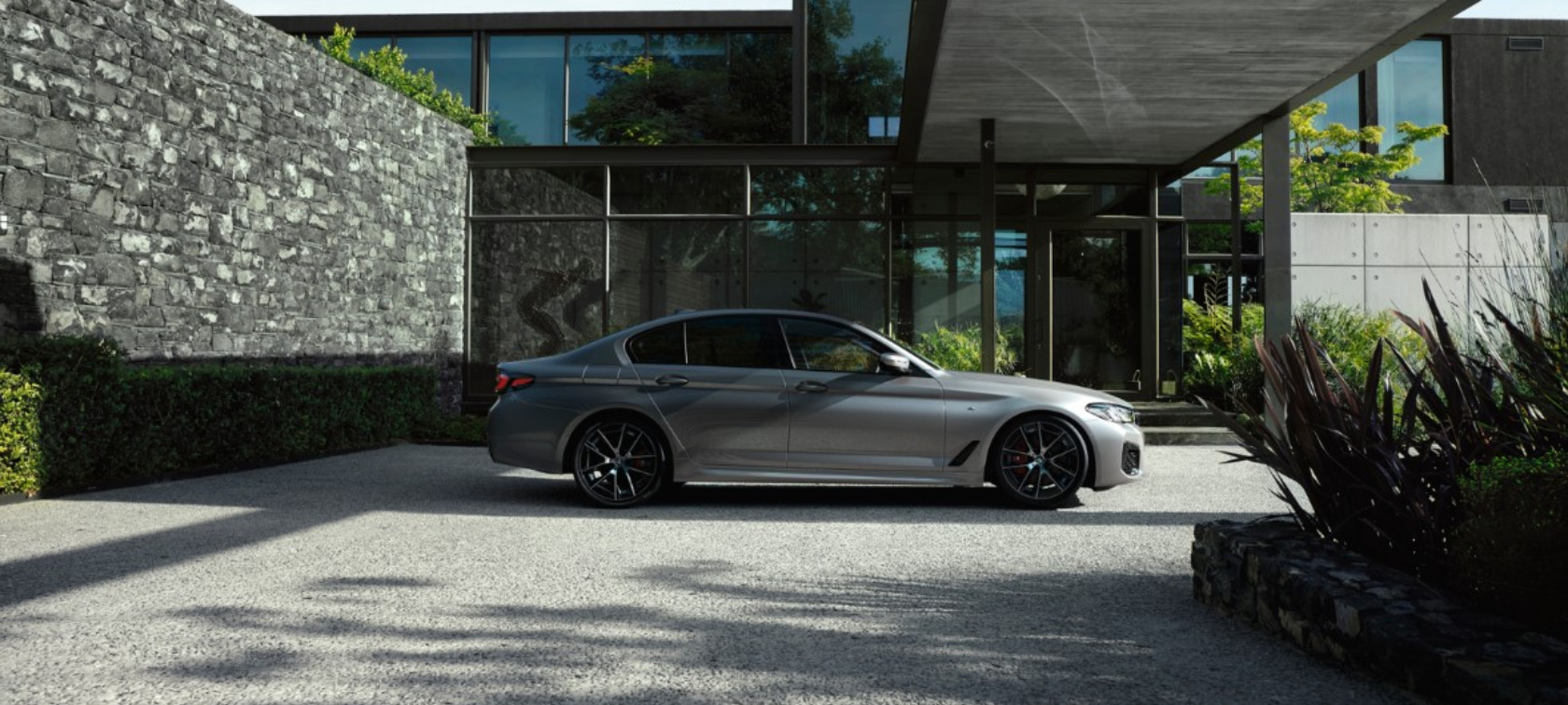 BMW Série 5 Berline d'occasion, grise, garée sur une propriété privée