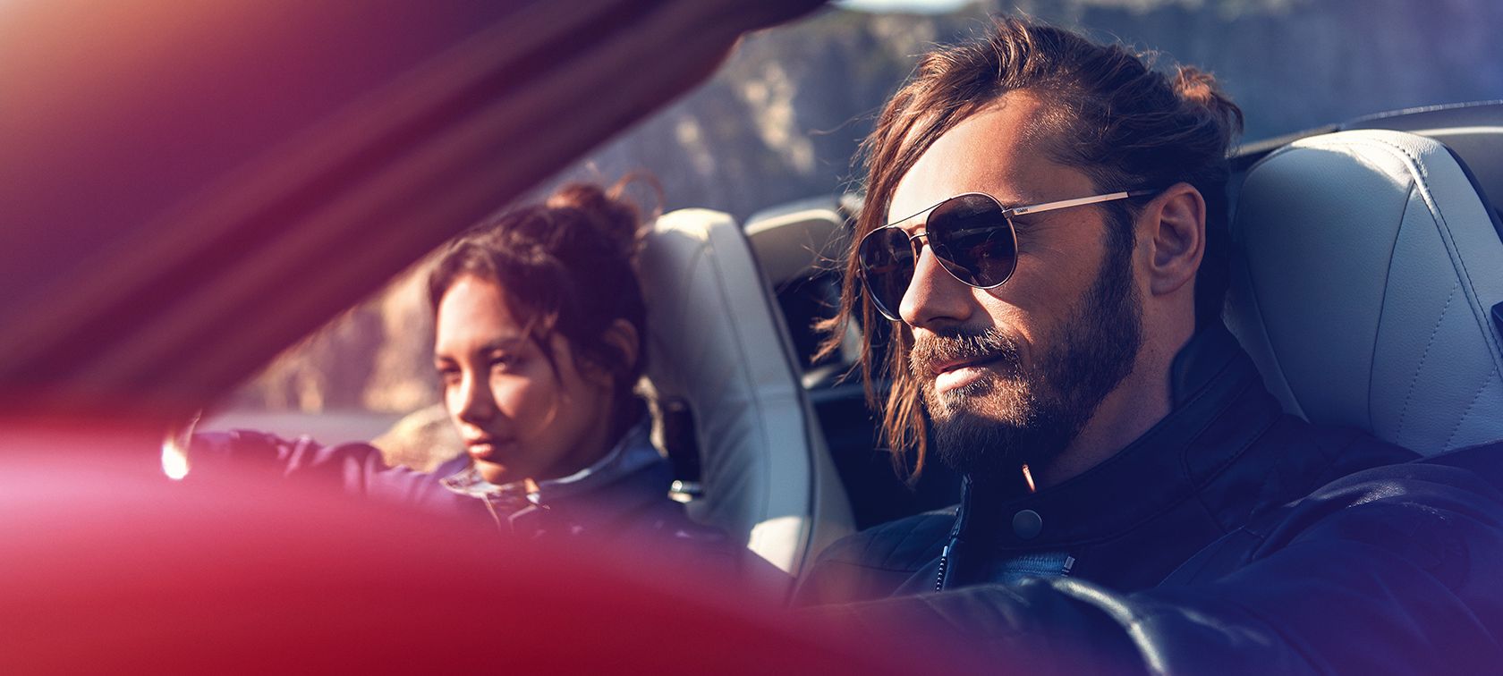 Un homme et une femme au soleil dans un cabriolet BMW Un homme et une femme au soleil dans un cabriolet BMW