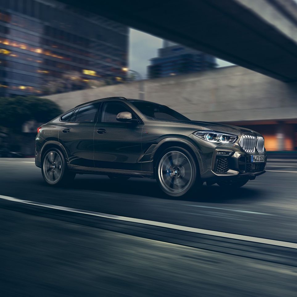 BMW X6 G06. La BMW X6 vue de trois quarts avant en marche devant un décor urbain G06